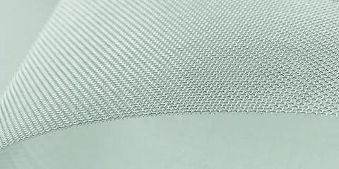 Nahaufnahme eines grauen Industriefilters aus feinem Metallgewebe mit erkennbarer Webstruktur.