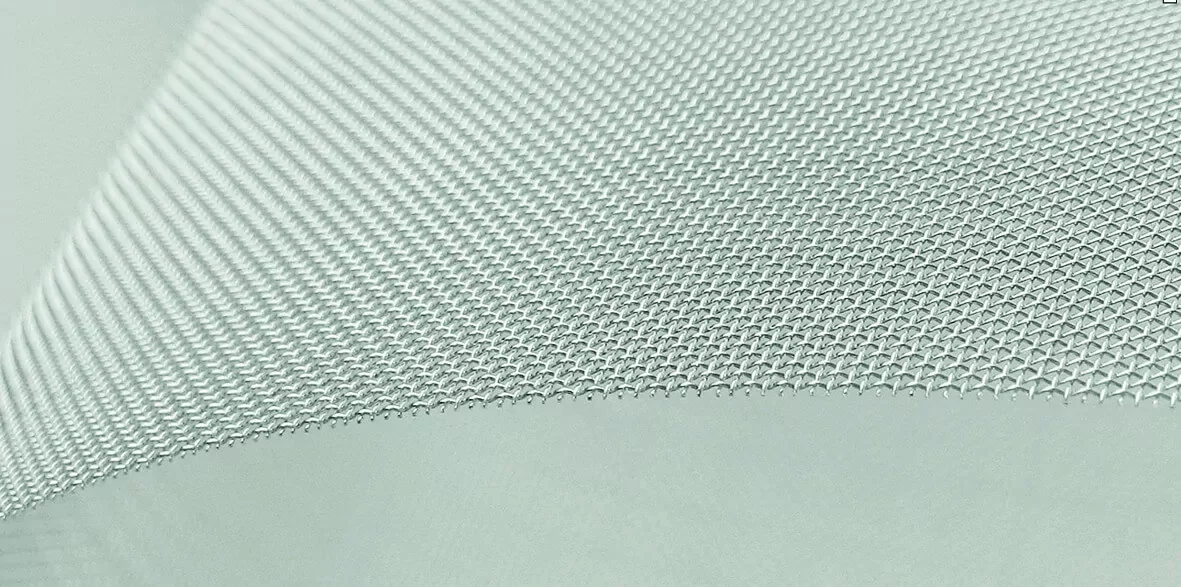 Nahaufnahme eines grauen Industriefilters aus feinem Metallgewebe mit erkennbarer Webstruktur.