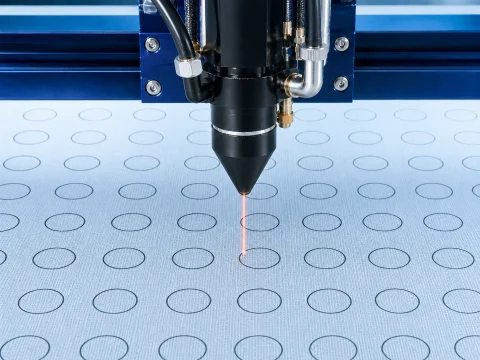 Laser-Codex: Industrieller Laserkopf beim präzisen Schneiden von Kreisen in Filtermaterial